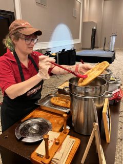 A woman prepares Beaver Tails pastry at the WordCamp Canada 2024 after party